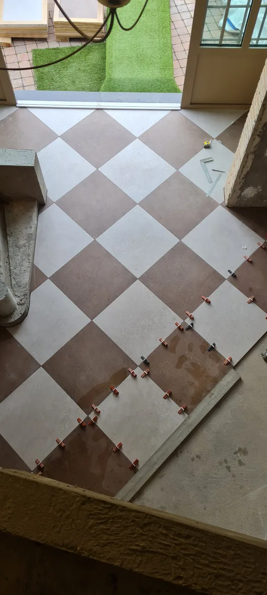 Pose en cours du carrelage damier diagonal à Sin-le-Noble, croisillons autonivelants