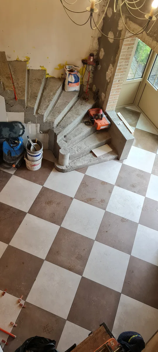 Carrelage damier autour de l'escalier béton à Sin-le-Noble, chantier en cours